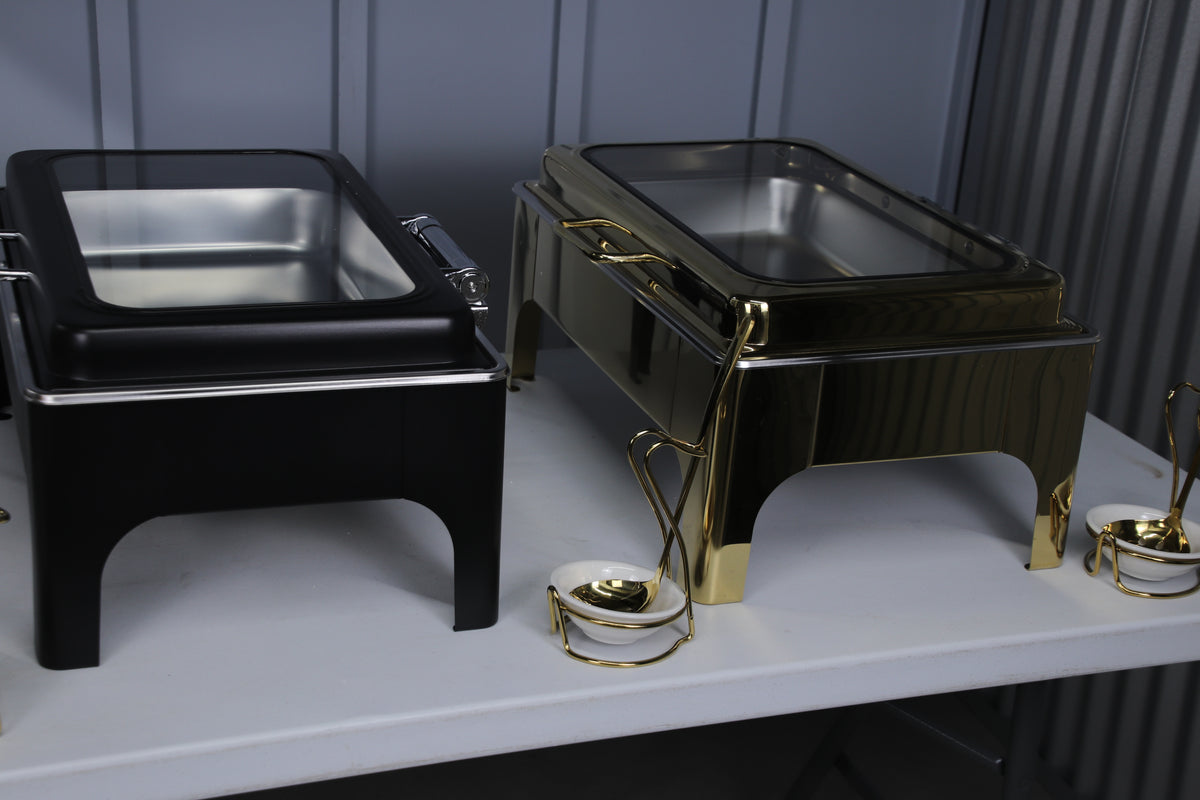 Jet black Crystal Crown rectangle chafing dish next to a gold one, lids closed