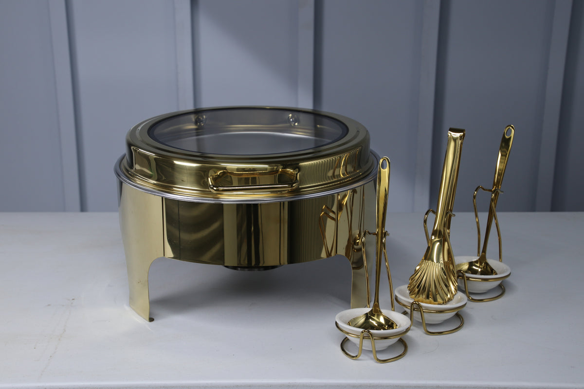 Gold Crystal Crown round chafing dish with the glass lid closed, next to serving utensils