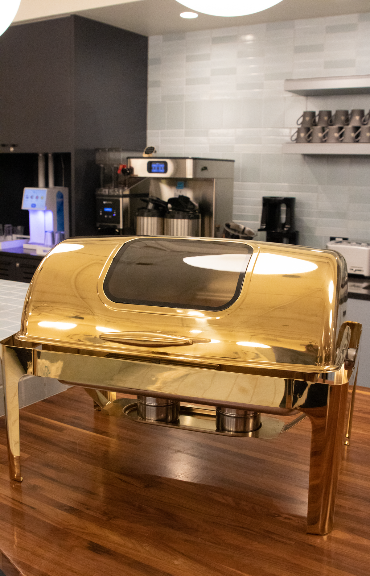 Gold Rolling Top rectangle chafing dish, closed, on a wooden counter