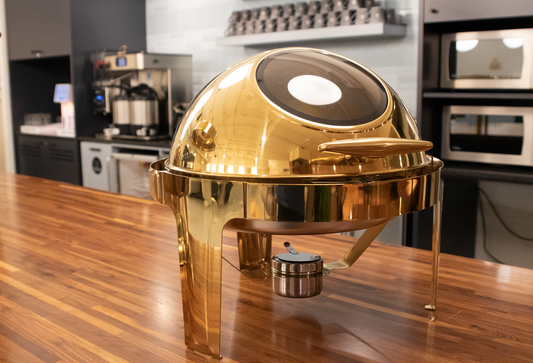 Gold Rolling Top round chafing dish closed on a wooden counter