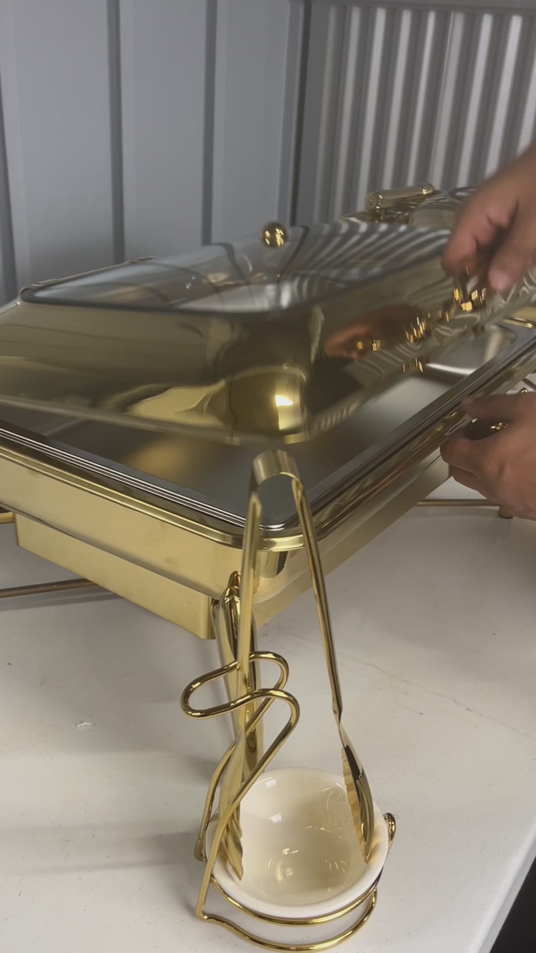 Video: lifting the glass lid on a gold rectangle chafing dish